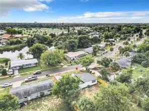 an aerial view of residential houses with outdoor space and trees