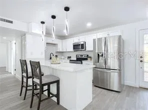 a kitchen with kitchen island a refrigerator and a stove top oven
