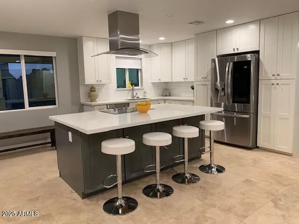 a kitchen with stainless steel appliances granite countertop a sink and a refrigerator