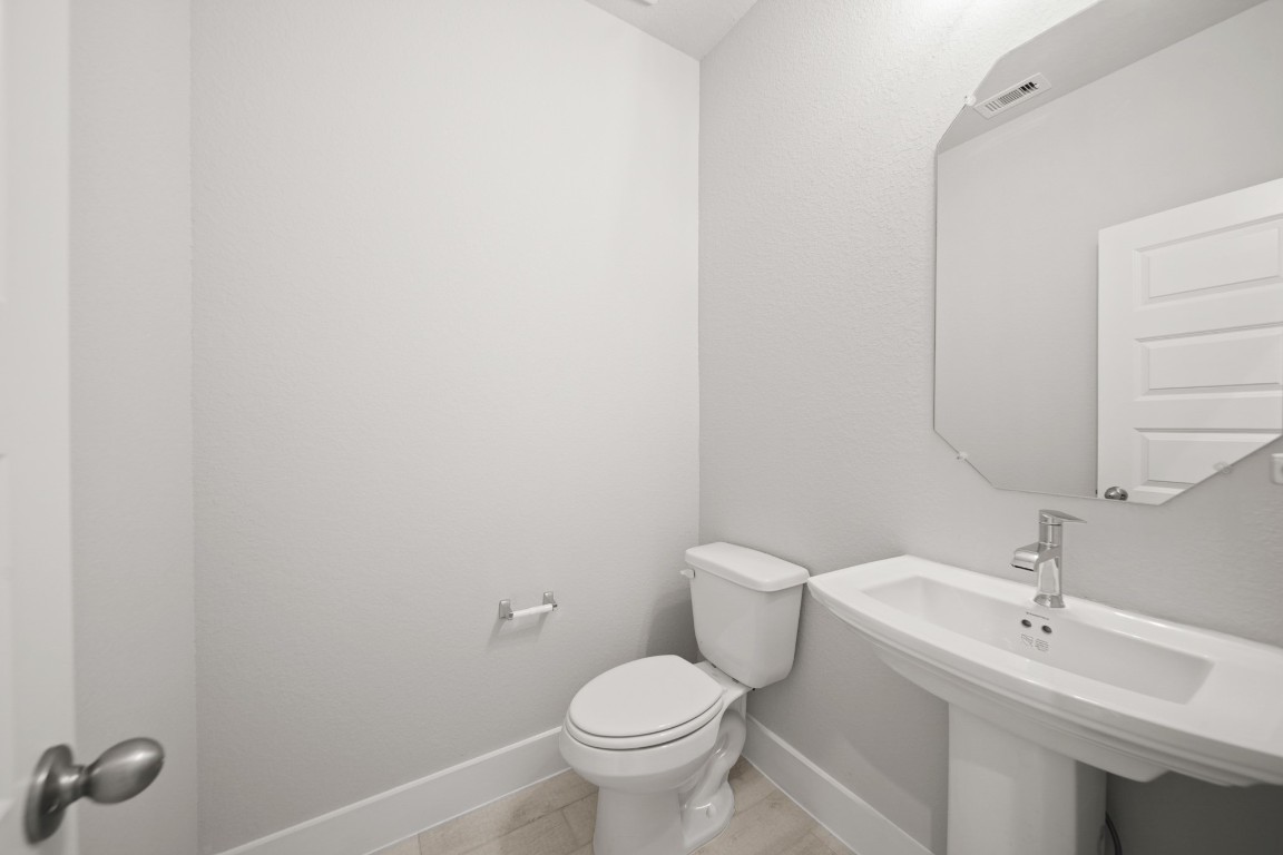 412 Elmbrook Terrace Way Waller, TX 77484 - Photo 14 of 38 a bathroom with a toilet a sink and mirror
