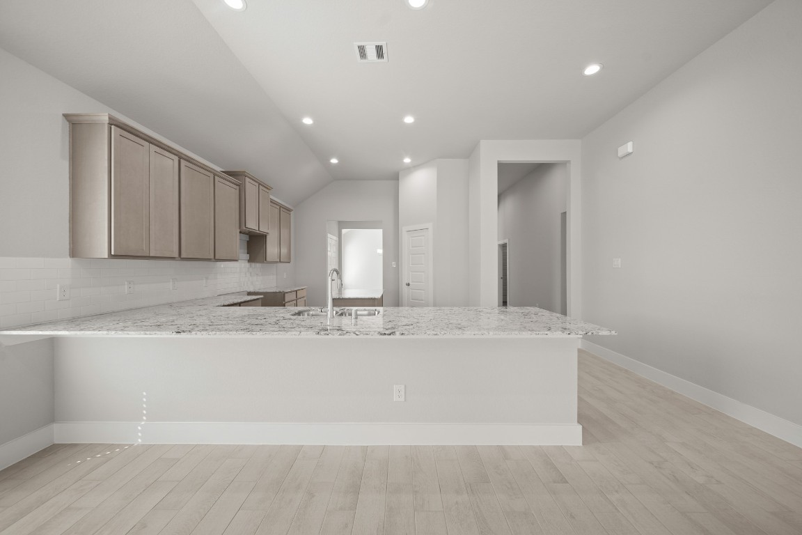 412 Elmbrook Terrace Way Waller, TX 77484 - Photo 2 of 38 a large white kitchen with a sink and dishwasher a refrigerator with wooden floor