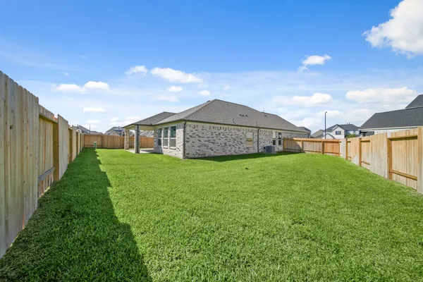 a view of a house with a big yard and large tree