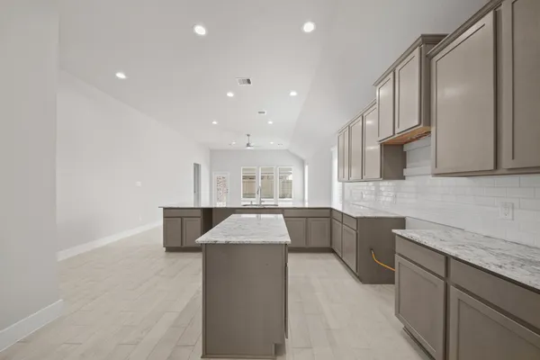 a kitchen with granite countertop a sink and white cabinets