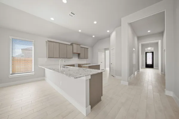 a large kitchen with stainless steel appliances granite countertop a large counter top a sink and a refrigerator