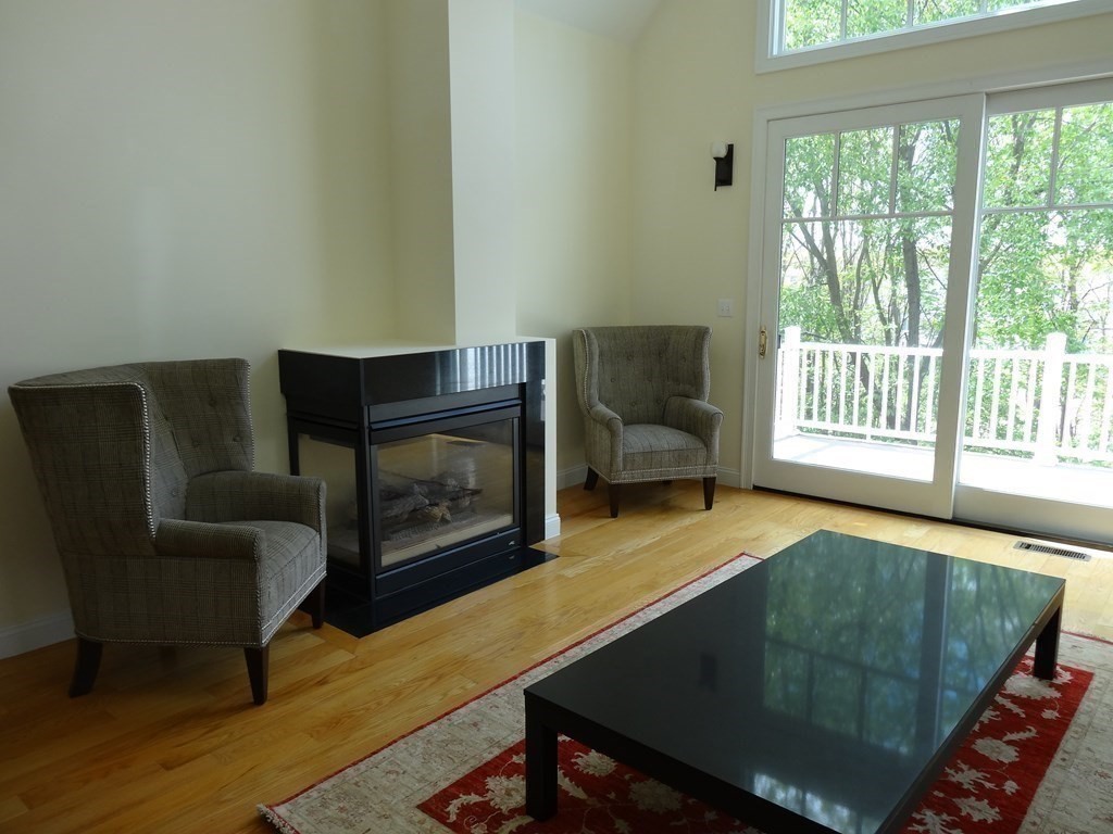 3 Deer Path Lane, Unit 3 Reading, MA 01867 - Photo 9 of 14 a living room with furniture rug and a fireplace