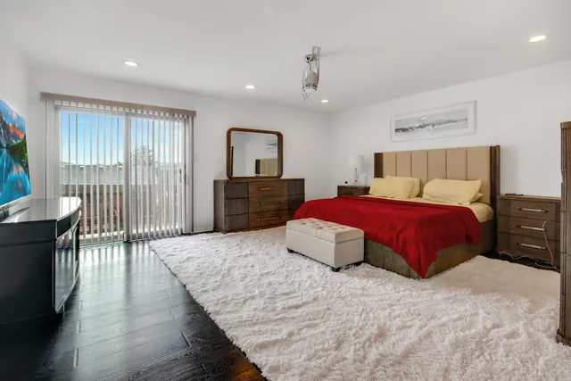 a bedroom with a large bed and wooden floor