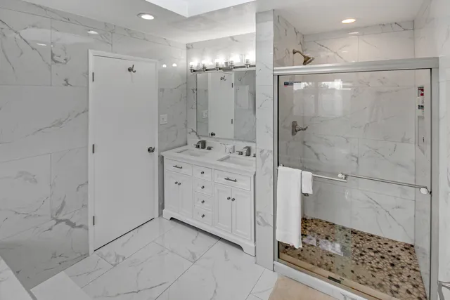 a bathroom with a glass shower door and a sink