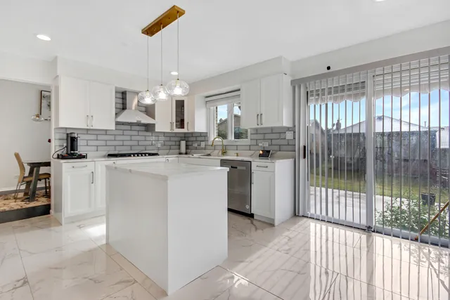 a kitchen with kitchen island a sink a counter top space appliances and cabinets