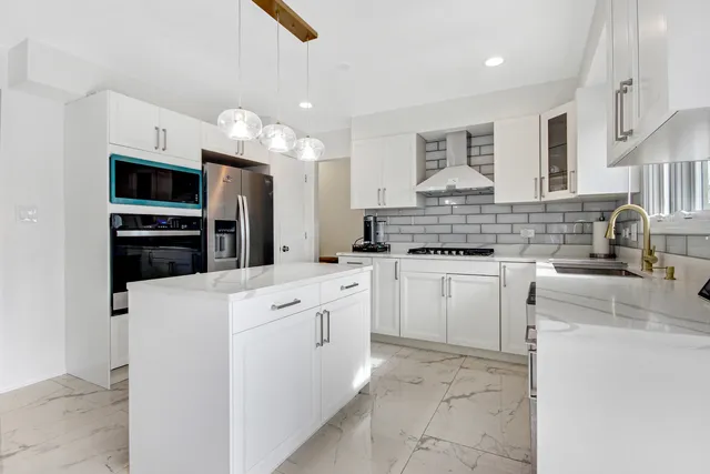 a kitchen with white cabinets and stainless steel appliances