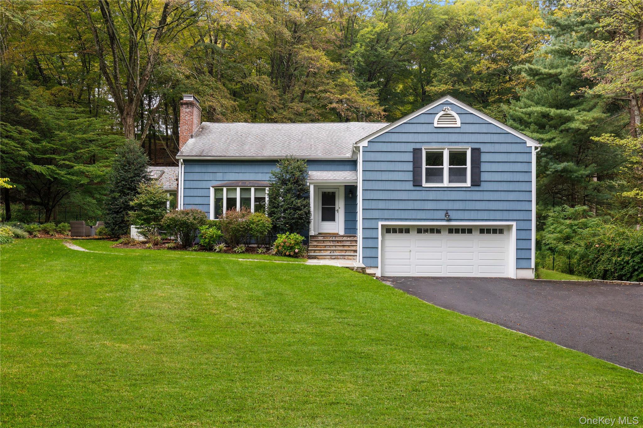 86 Seven Bridges Road Chappaqua, NY 10514 - Photo 1 of 33 a front view of a house with a yard and garage