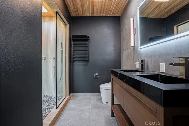 a bathroom with a sink a toilet and shower