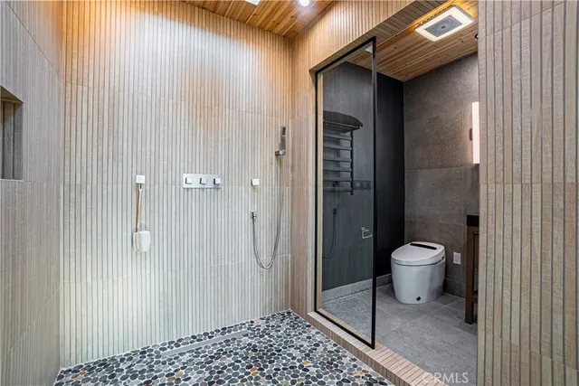 a bathroom with a granite countertop shower and a toilet