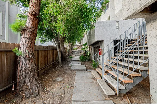 a view of backyard with wooden fence and trees