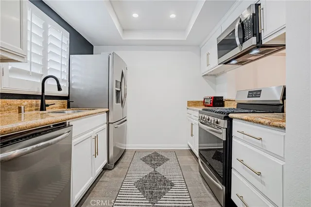a kitchen with stainless steel appliances granite countertop a stove and a refrigerator