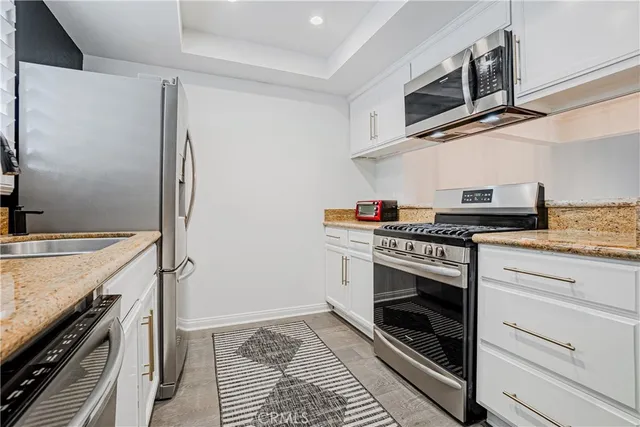a kitchen with stainless steel appliances granite countertop a stove and a refrigerator
