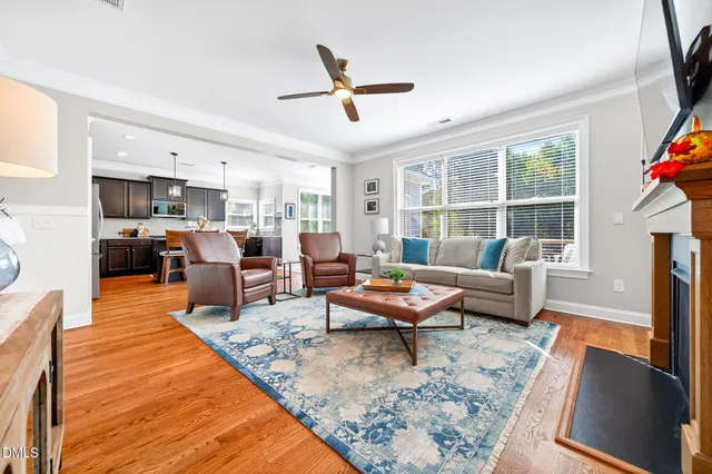 a living room with furniture kitchen view and a large window