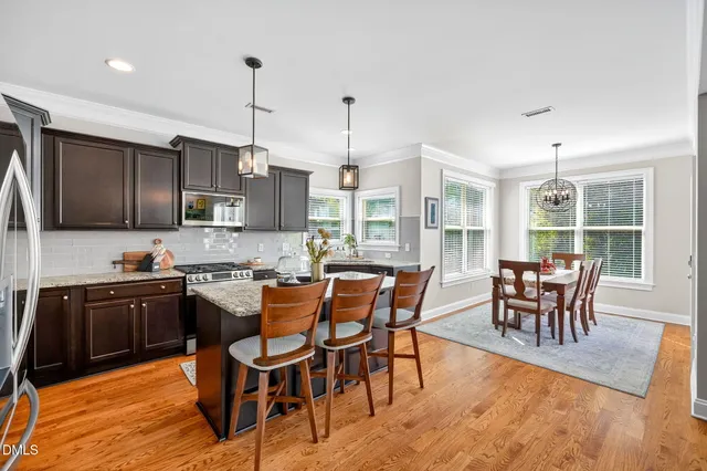 a kitchen with stainless steel appliances granite countertop a sink a stove a refrigerator and island