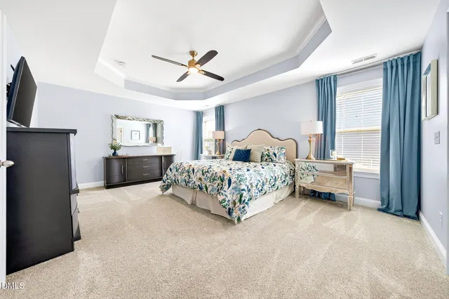 a bedroom with a beds chandelier and a window