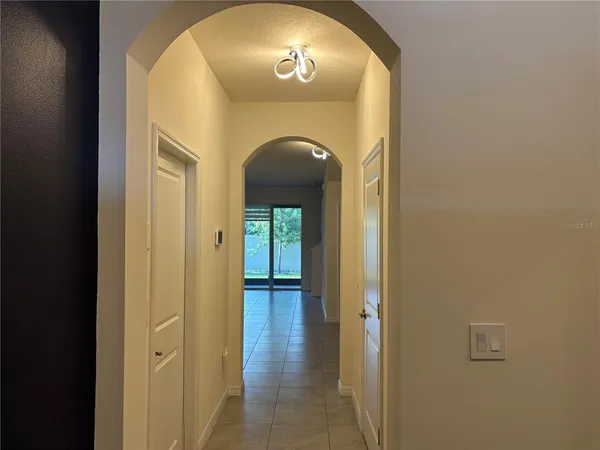 a hallway with wooden floor mirror and a bathroom