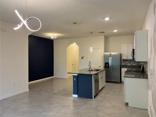 a kitchen with stainless steel appliances granite countertop a sink a stove and a refrigerator