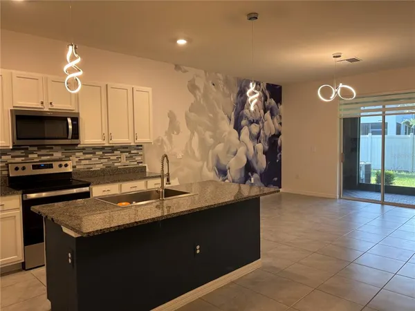 a kitchen with a sink a stove and a microwave
