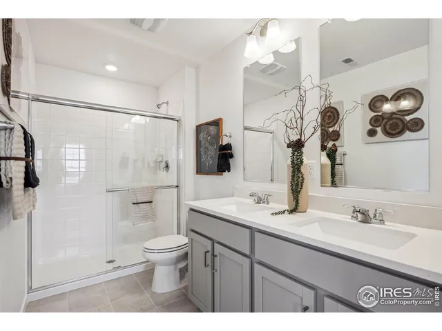 a bathroom with a double vanity sink mirror and toilet