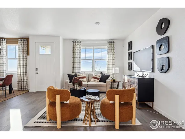 a living room with furniture a rug and white walls