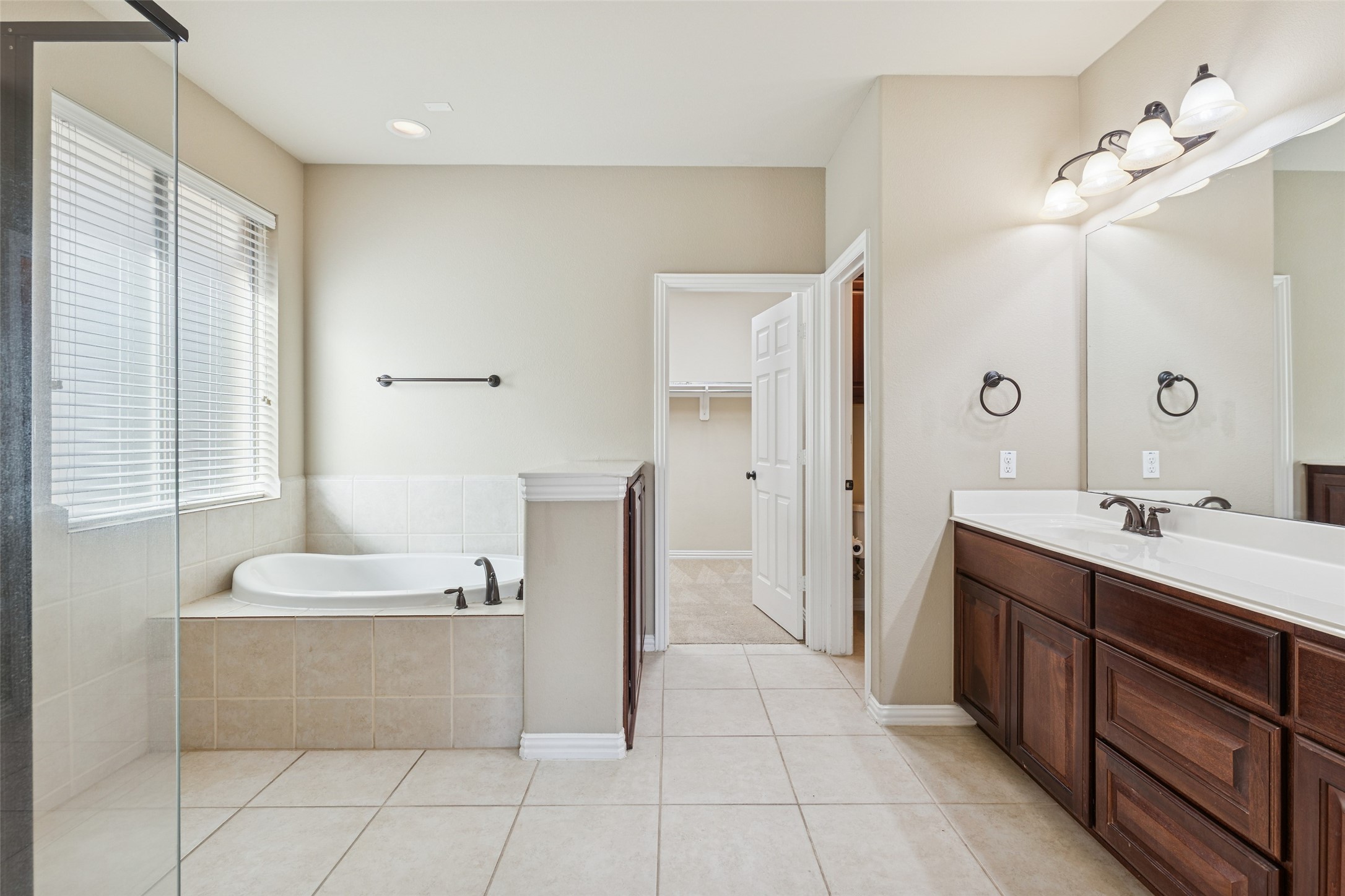 11 Vershire Circle Magnolia, TX 77354 - Photo 21 of 44 a bathroom with a double vanity sink a mirror and a bathtub
