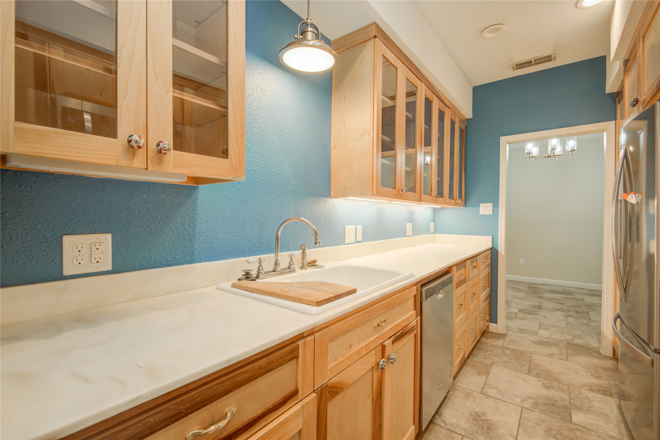 7449 Brompton Street, Unit 7449 Houston, TX 77025 - Photo 15 of 46 Glass cabinetry & natural wood finish is lovely against the accent wall paint & solid surface countertops