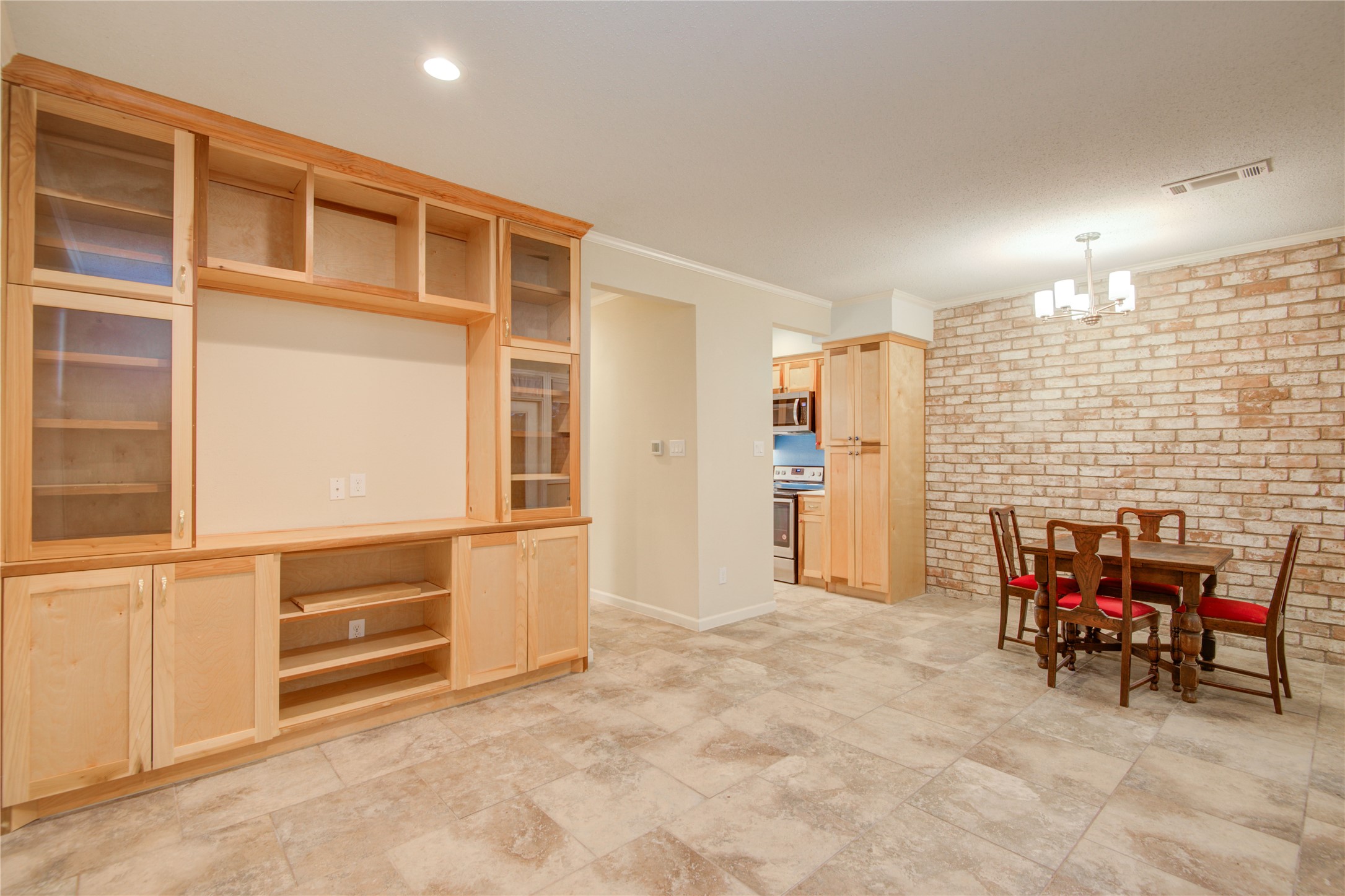 7449 Brompton Street, Unit 7449 Houston, TX 77025 - Photo 18 of 46 Natural wood finish on the built ins w/ brick accent wall & tile floor throughout downstairs