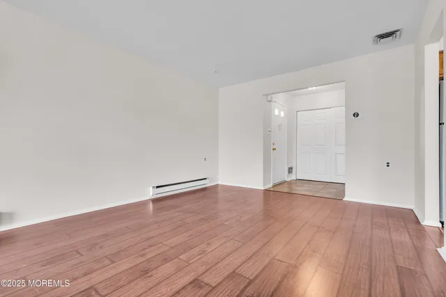 a view of an empty room and wooden floor