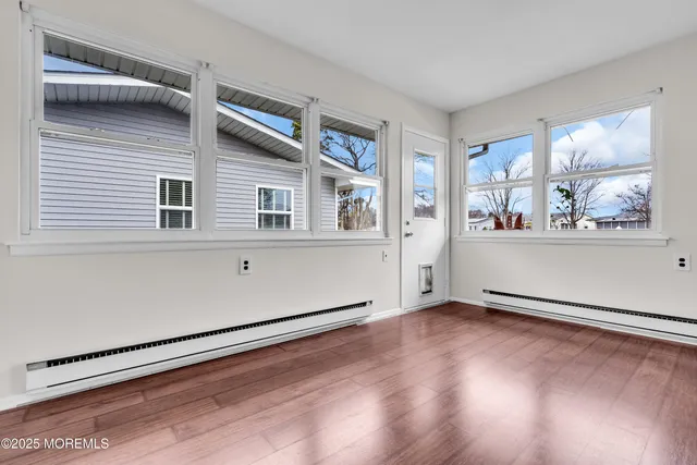 a view of a livingroom with wooden floor and a window