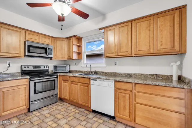 a kitchen with stainless steel appliances granite countertop a stove sink microwave and refrigerator