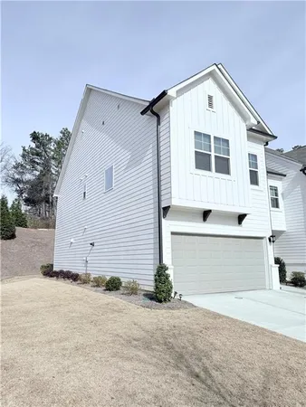 a view of a white house with a yard and garage
