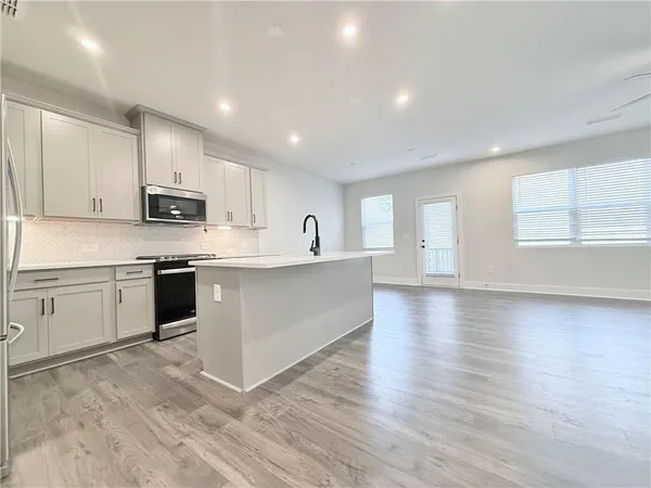 a kitchen with stainless steel appliances granite countertop a stove a sink and a refrigerator