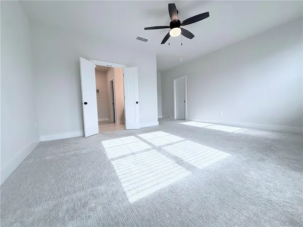 a view of a room with a ceiling fan and window