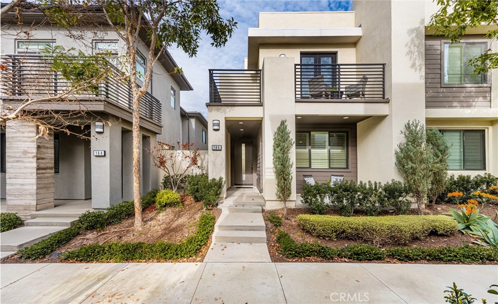 a front view of a house with a yard and potted plants