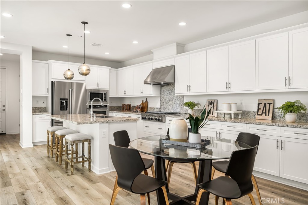 186 Terrapin Irvine, CA 92618 - Photo 7 of 39 a kitchen with kitchen island granite countertop a dining table chairs sink and white cabinets