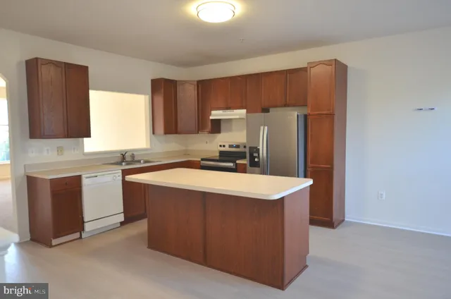 a kitchen with stainless steel appliances granite countertop a refrigerator a stove a sink and a microwave