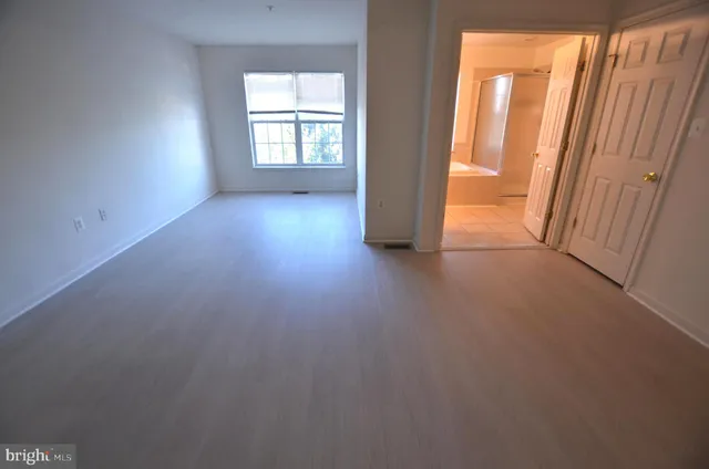an empty room with windows and closet
