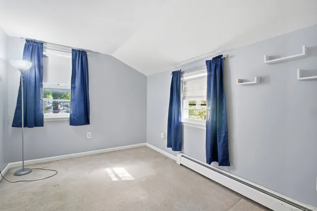 a view of an empty room with window and bathroom