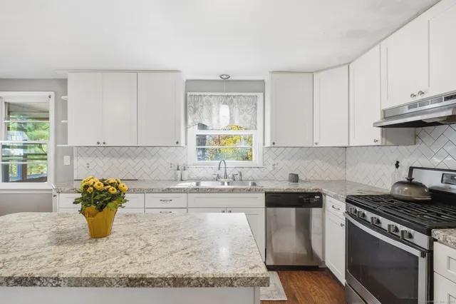 a kitchen with stainless steel appliances granite countertop a sink stove and window