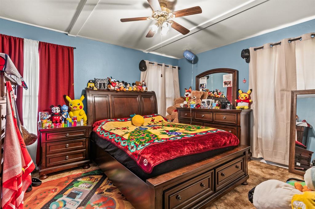 1210 East 4th Street Mount Pleasant, TX 75455 - Photo 11 of 28 a bedroom with a bed and a chandelier