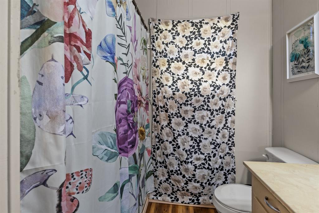 1210 East 4th Street Mount Pleasant, TX 75455 - Photo 12 of 28 a white toilet sitting next to a shower curtain