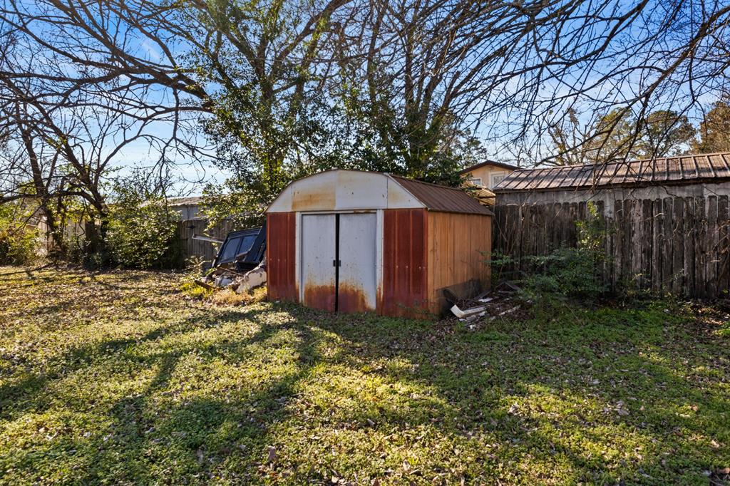 1210 East 4th Street Mount Pleasant, TX 75455 - Photo 28 of 28 a view of a house with a yard and large trees