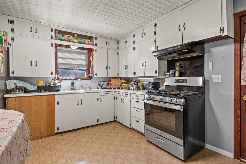 1210 East 4th Street Mount Pleasant, TX 75455 - Photo 10 of 28 a kitchen with stainless steel appliances granite countertop a stove a sink and a refrigerator