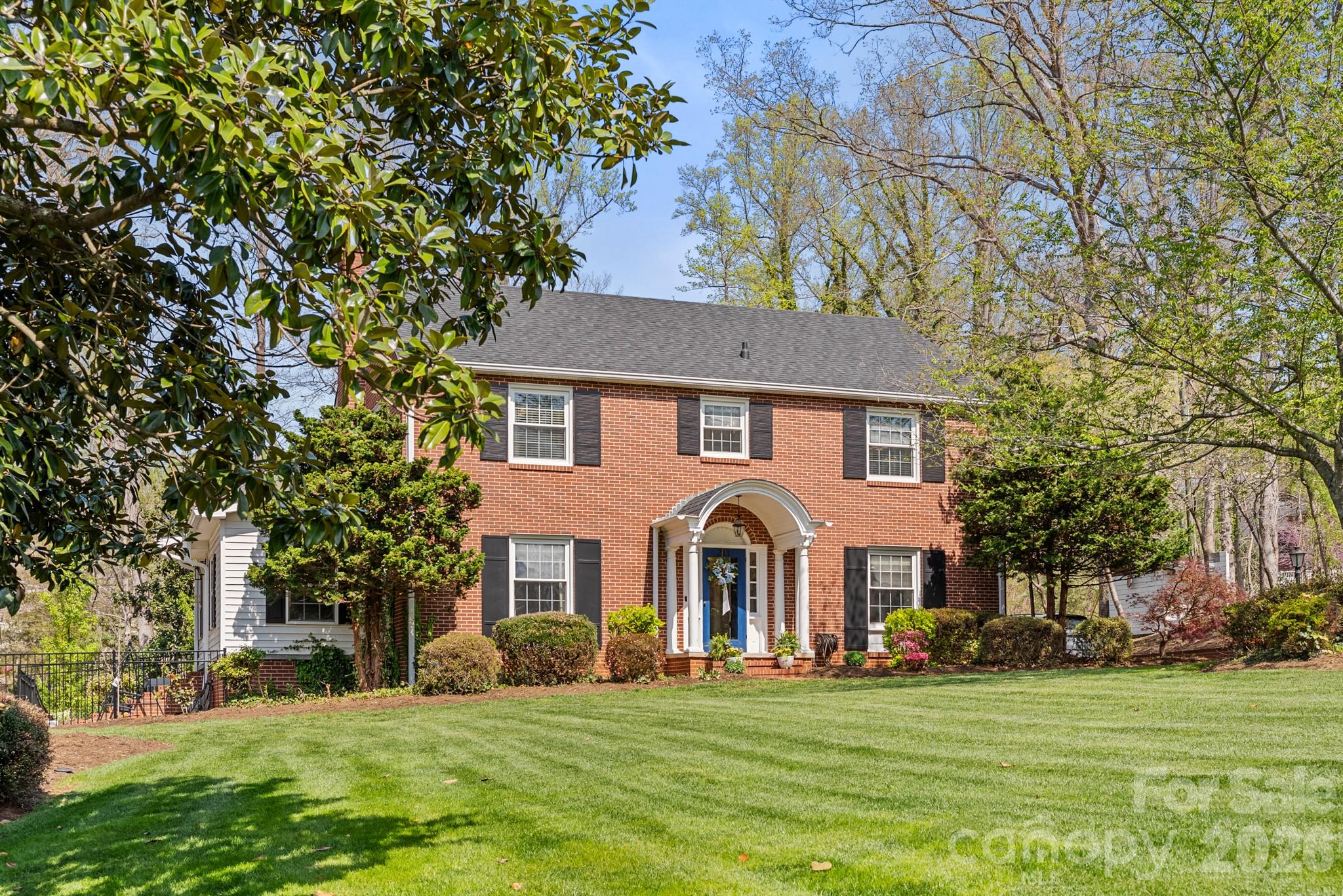 211 Dutchman Creek Road Elkin, NC 28621 - Photo 11 of 48 a view of a white house with a big yard and large trees