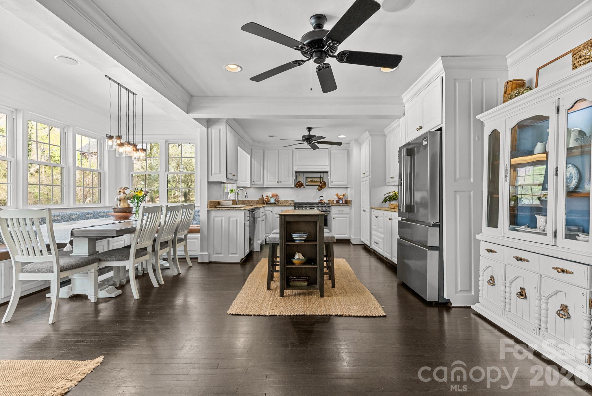 211 Dutchman Creek Road Elkin, NC 28621 - Photo 18 of 48 a kitchen with stainless steel appliances kitchen island granite countertop a stove a refrigerator a dining table and chairs with wooden floor