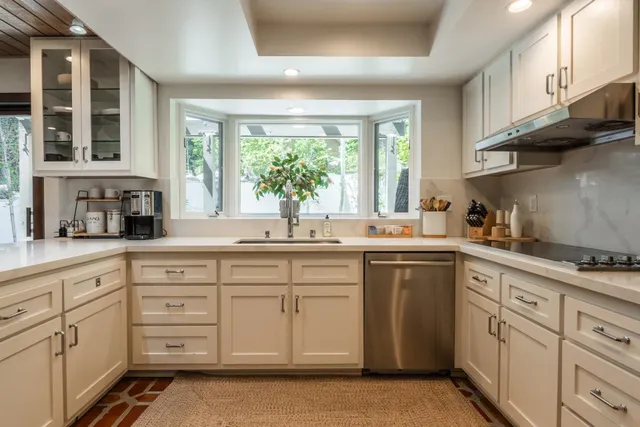 a kitchen with white cabinets and white appliances