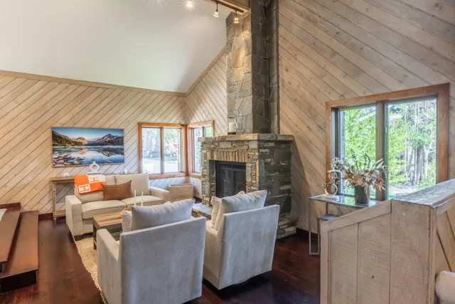 a living room with furniture a fireplace and a floor to ceiling window
